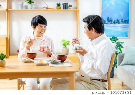 ダイニングで食事するシニア夫婦 101073351