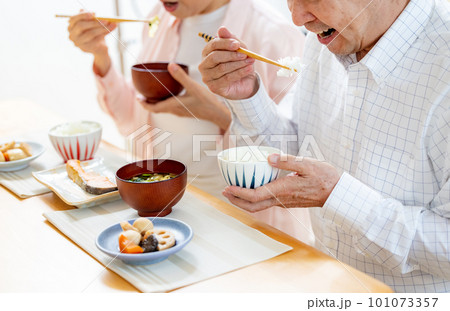 ダイニングで食事するシニア夫婦 101073357