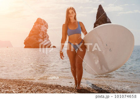Woman sea sup. Close up portrait of happy young caucasian woman with long hair looking at camera and smiling. Cute woman portrait in bikini posing on sup board in the sea Woman sea sup. Close up portrait of happy young caucasian woman with long hair looking at camera and smiling. Cute woman portrait in bikini posing on sup board in the sea 101074658