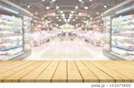 Empty wood table top with supermarket grocery store aisle and shelves blurred background 101075600