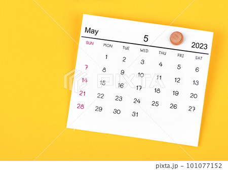 The May 2023 calendar and wooden push pin on yellow background. 101077152