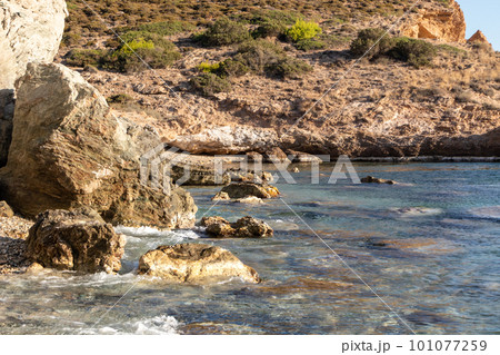 Wild Aegean sea with rocky cliffs and blue water Wild Aegean sea with rocky cliffs and blue water 101077259