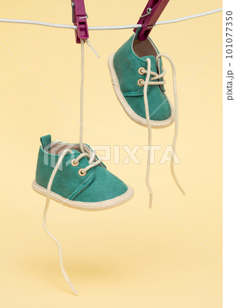 Baby shoes hanging on the clothesline. Newborn concept Baby shoes hanging on the clothesline. Newborn concept 101077350