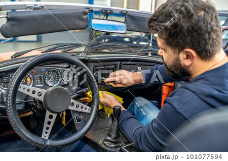 cleaning the interior of the old car with a brush and rag cleaning the interior of the old car with a brush and rag 101077694