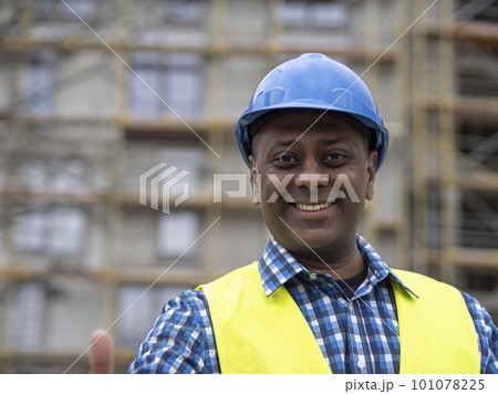Portrait of a smiling Indian civil engineer or factory worker wearing a blue helmet and looking at camera Portrait of a smiling Indian civil engineer or factory worker wearing a blue helmet and looking at camera 101078225
