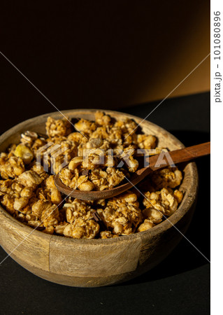 Homemade granola with nuts and seeds in eco tableware wooden bowl. Healthy snack on breakfast. Muesli from oatmeal, raisins, honey, cranberry, flax, almond, cashew, freshly baked Homemade granola with nuts and seeds in eco tableware wooden bowl. Healthy snack on breakfast. Muesli from oatmeal, raisins, honey, cranberry, flax, almond, cashew, freshly baked 101080896