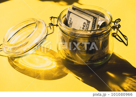 Dollar banknote saving money in glass jar. Consumption and economy Collecting money. Tips. Business, finance, saving, banking and people concept. Extra money, passive income 101080966