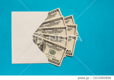 Dollar banknote saving money in envelope on blue background copy space. Consumption and economy Collecting money. Tips. Business, finance, saving, banking and people concept. Extra money, passive 101080986