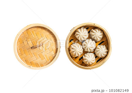 Steamed baozi dumplings stuffed with meat in a bamboo steamer. Isolated on white background. Steamed baozi dumplings stuffed with meat in a bamboo steamer. Isolated on white background. 101082149