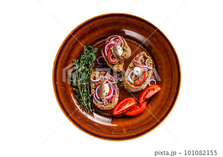 Spanish tapas on bread with olive oil, herbs, tomatoes and spicy anchovy fillets. Isolated on white background. Spanish tapas on bread with olive oil, herbs, tomatoes and spicy anchovy fillets. Isolated on white background. 101082155