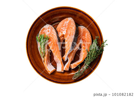 Salmon raw steaks on rustic plate with herbs. Isolated on white background. Salmon raw steaks on rustic plate with herbs. Isolated on white background. 101082182