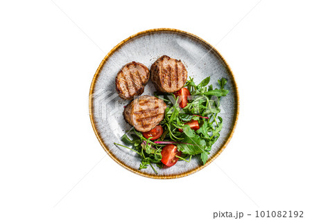 Grilled pork medallions steaks, tenderloin fillet with salad in plate. Isolated on white background. Grilled pork medallions steaks, tenderloin fillet with salad in plate. Isolated on white background. 101082192