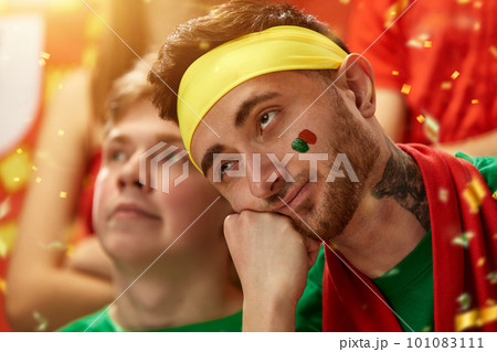Bored male face. Sport fans emotionally cheering up favourite football, soccer team of portugal at stadium during game Bored male face. Sport fans emotionally cheering up favourite football, soccer team of portugal at stadium during game 101083111