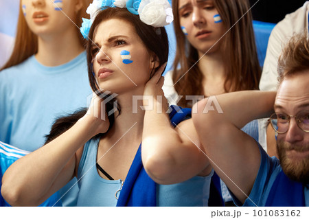 Young people watching football match at stadium. Losing goal, sad emotions. Cheering up favourite football, soccer team of greece 101083162