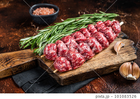 Raw traditional shish kebab Skewers with beef meat ans spices. Dark background. Top view 101083526