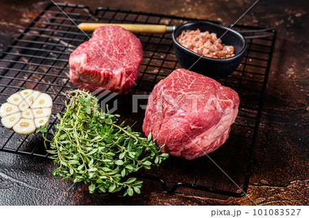 Raw Fillet Mignon Beef steaks, Dry aged tenderloin meat. Dark background. Top view Raw Fillet Mignon Beef steaks, Dry aged tenderloin meat. Dark background. Top view 101083527