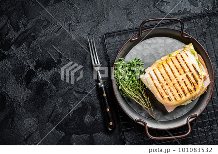 Club sandwich panini with Prosciutto ham. Black background. top view. copy space Club sandwich panini with Prosciutto ham. Black background. top view. copy space 101083532