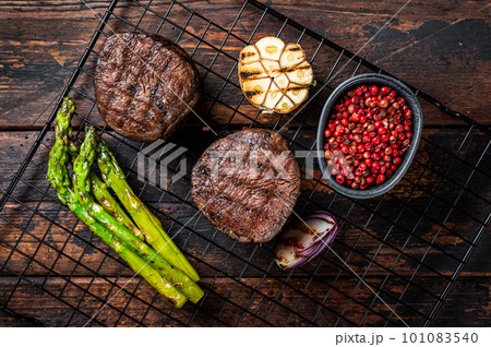 Fillet Mignon grilled Steak with asparagus, beef tenderloin meat. Wooden background. Top view Fillet Mignon grilled Steak with asparagus, beef tenderloin meat. Wooden background. Top view 101083540