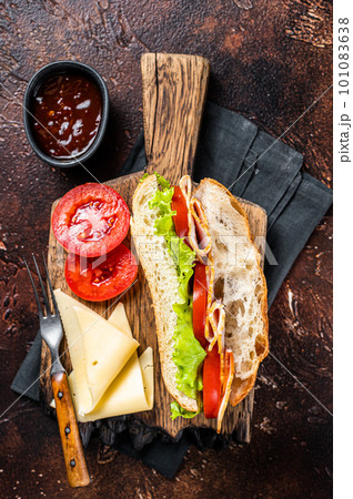 Smoked turkey sandwich with ham, cheese, tomato and Lettuce. Dark background. Top view 101083638