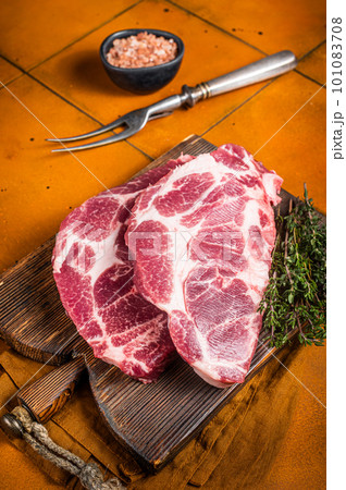 Raw pork steak chops, neck meat with herbs. Orange background. Top view 101083708