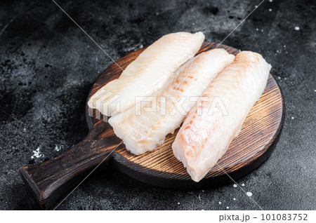 Fillets of codfish, raw cod fish meat. Black background. Top view 101083752