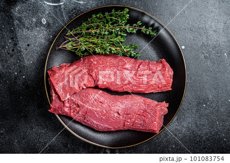 Halal fresh lamb tenderloin meat, Mutton sirloin fillet with thyme. Black background. Top view 101083754