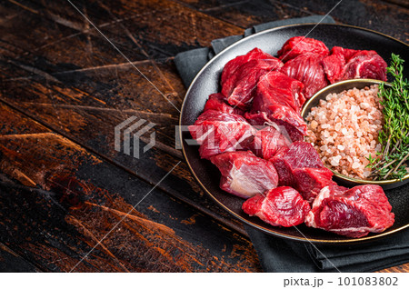 Raw lean diced casserole beef meat for cooking Goulash. Wooden background. Top view. Copy space 101083802