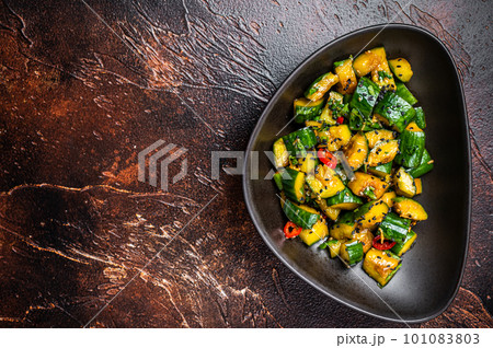 Chinese smashed cucumbers with herbs and sesame oil. Dark background. Top view. Copy space Chinese smashed cucumbers with herbs and sesame oil. Dark background. Top view. Copy space 101083803