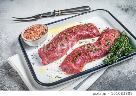 Fresh lamb sirloin meat, Mutton tenderloin fillet with herbs and spices ready for cooking. White background. Top view Fresh lamb sirloin meat, Mutton tenderloin fillet with herbs and spices ready for cooking. White background. Top view 101083809