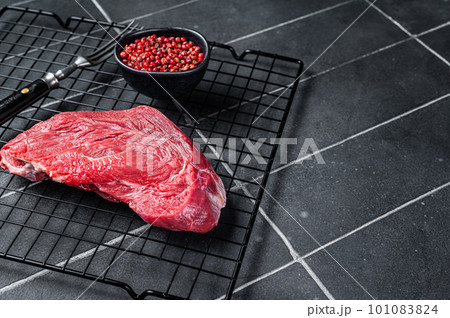 Raw beef meat piece for grilling with spices. Black background. Top view. Copy space 101083824