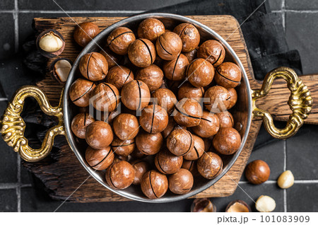 Macadamia nuts in a shell ready to eat. Black background. Top view Macadamia nuts in a shell ready to eat. Black background. Top view 101083909