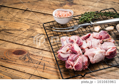 Fresh Raw chicken stomachs, gizzards on a grill ready for cooking with herbs. Wooden background. Top view. Copy space Fresh Raw chicken stomachs, gizzards on a grill ready for cooking with herbs. Wooden background. Top view. Copy space 101083961
