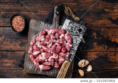 Butcher board with raw chicken hearts. Wooden background. Top view Butcher board with raw chicken hearts. Wooden background. Top view 101083968