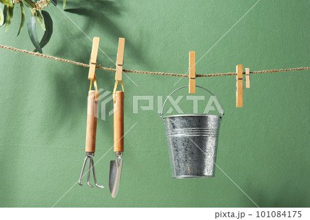 Gardening tools hanging on the rope, natural green background 101084175