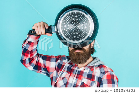 male hipster with fashionable groomed hair and beard cooking with pan, utensil male hipster with fashionable groomed hair and beard cooking with pan, utensil 101084303