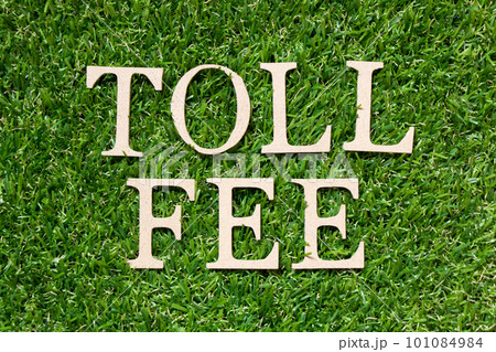 Wood alphabet letter in word toll fee on artificial green grass background Wood alphabet letter in word toll fee on artificial green grass background 101084984