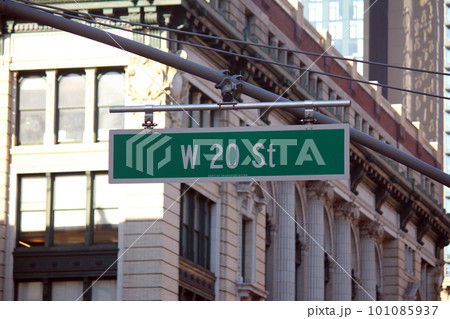 Green big West 20th Street sign hanging on a arch pole in the streets of midtown Manhattan 101085937