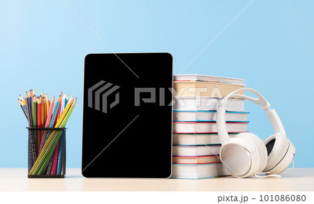 Tablet with colorful pencils and stack of books 101086080