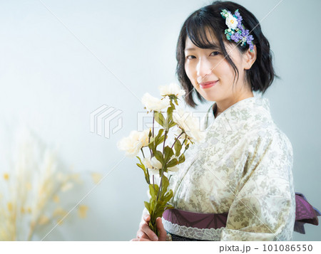 手に花を持ち、洋風な花柄小紋(着物)を着る女性:白背景 手に花を持ち、洋風な花柄小紋(着物)を着る女性:白背景 101086550