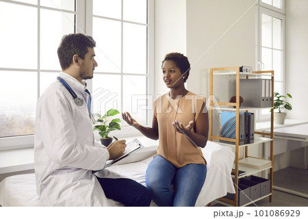 Worried young black woman having conversation with male doctor at clinic or hospital Worried young black woman having conversation with male doctor at clinic or hospital 101086929