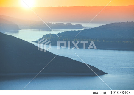Beautiful evening landscape. River with rocky hills at sunset in autumn. Beautiful nature Beautiful evening landscape. River with rocky hills at sunset in autumn. Beautiful nature 101088403