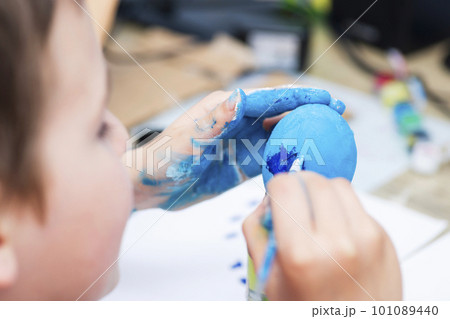 A boy painting Easter eggs at home. A child preparing the easter eggs for Easter 101089440