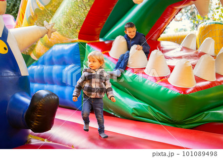 Happy kids having fun on colorful inflatable attraction playground 101089498