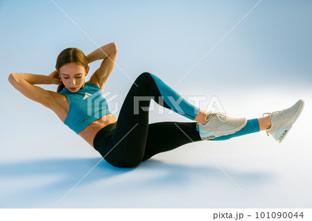 Active woman shaking press on studio background. Fitness, healthy lifestyle and sport concept Active woman shaking press on studio background. Fitness, healthy lifestyle and sport concept 101090044