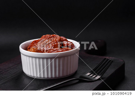 Delicious sun dried tomatoes in oil in a white ceramic bowl 101090419