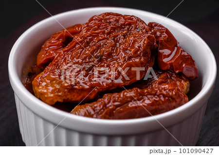 Delicious sun dried tomatoes in oil in a white ceramic bowl 101090427
