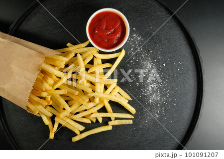 Chips fries and ketchup on a dark background. Top view Chips fries and ketchup on a dark background. Top view 101091207