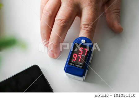 A pulse oximeter on a human finger measures oxygen in the blood. Top view 101091310