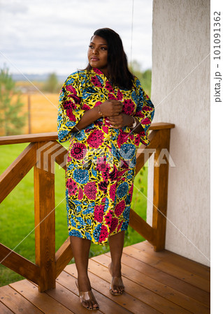 Beautiful african american woman enjoying evening on village and nature on terrace of country house. Diversity and inclusion and cottagecore concept Beautiful african american woman enjoying evening on village and nature on terrace of country house. Diversity and inclusion and cottagecore concept 101091362