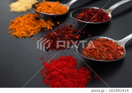 Spoons with seasonings and spices on a black background. Colorful spices in spoons Spoons with seasonings and spices on a black background. Colorful spices in spoons 101091414
